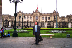 A man in suit and tie standing on the sidewalk.